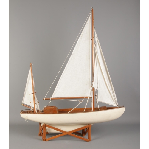 314 - A multi-sail model pond yacht on stand. 77cm tall (on stand).