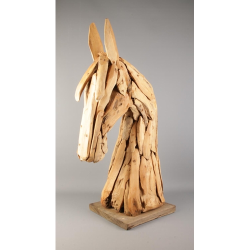 5 - A large decorative wooden sculpture of a horse's head. Approx. 90cm tall including base.