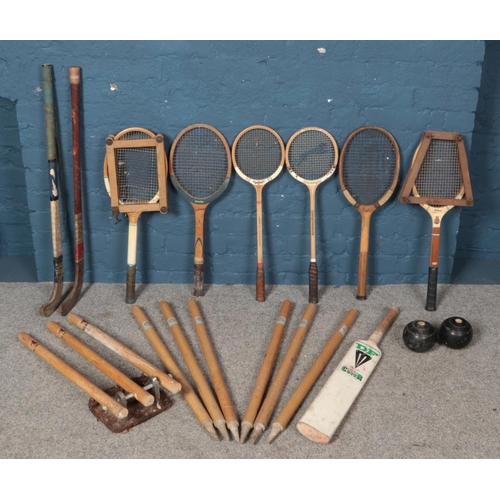 351 - A quantity of vintage sporting equipment. Including tennis rackets, cricket bat & stumps, lawn bowls... 