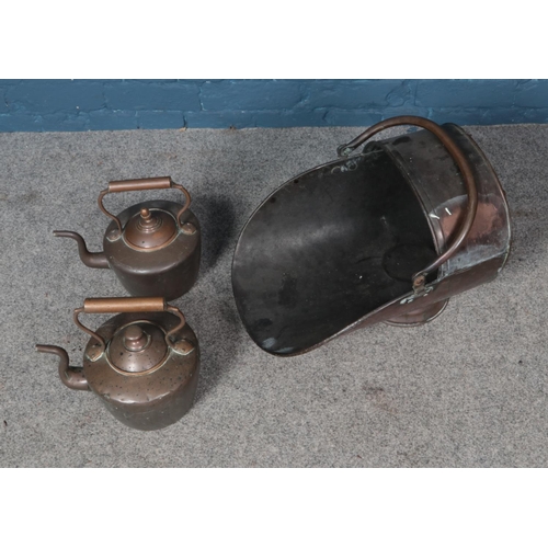 352 - A copper helmet shaped coal scuttle and two copper pots.