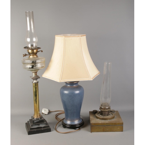 355 - Two brass paraffin lamps and one ceramic modern table lamp.