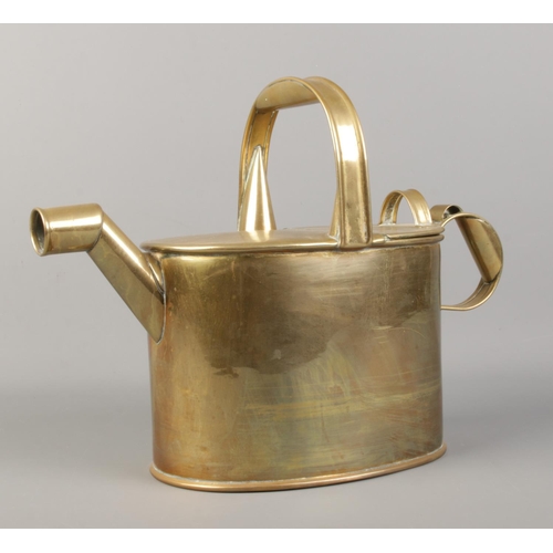 55 - A brass watering can, with hinged top. 26cm high.