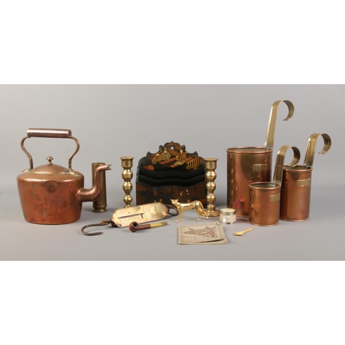 63 - An assortment of collectables, to include a pair of brass candlesticks, copper and brass pint measur... 