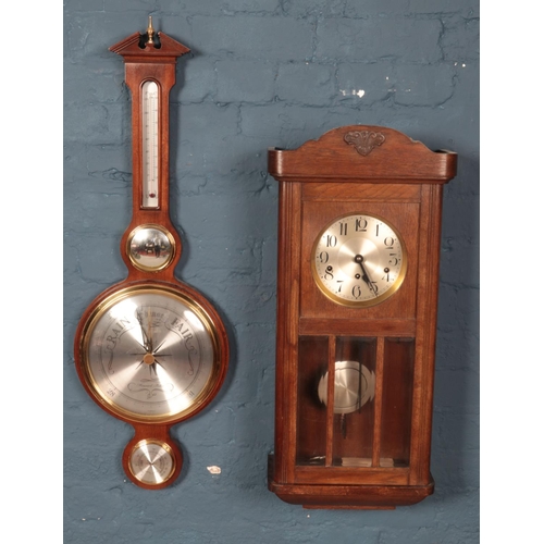 410 - A Howard Miller banjo barometer along with a carved oak wall clock.