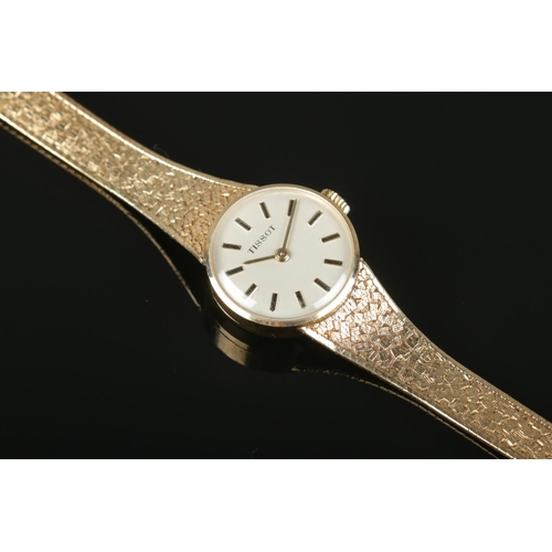 446 - A Ladies 9ct Gold Tissot manual wind wristwatch, with baton marker dial, textured gold bracelet stra... 