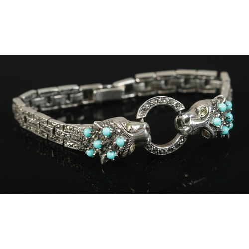 450 - A silver, marcasite and turquoise bracelet, featuring two cats clutching a hoop in their mouth. Tota... 