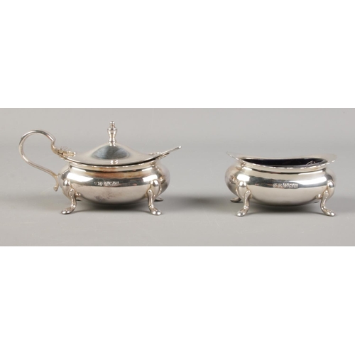 514 - A silver mustard pot and spoon, together with salt pot; both with Bristol blue glass liners. Both mu... 