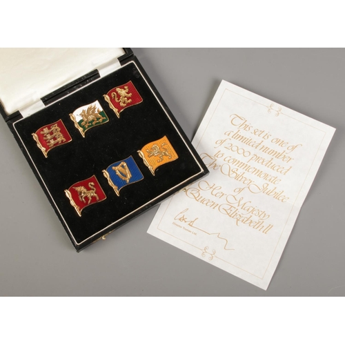 542 - A cased set of Truman Ltd yellow metal and enamel flags to commemorate Queen Elizabeth II silver jub... 