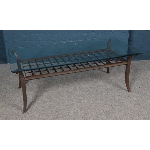 543 - A glass topped coffee table raised on metal frame with slatted under tier. Dimensions 123cm x 64cm x... 