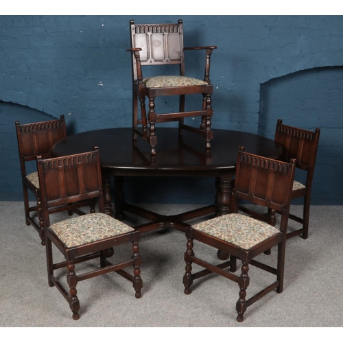 550 - An Ercol X frame extending dining table with four matching dining chairs and one carver.