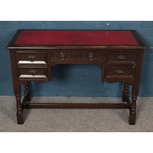 558 - A Priory style carved oak knee hole desk with red leather inset top. (73cm x 107cm)