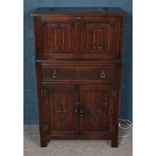 559 - A Jaycee carved oak drinks cabinet.