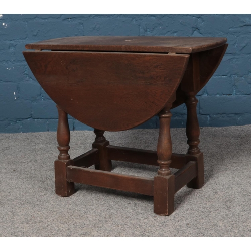 564 - A small oak drop leaf occasional table. Dimensions 57cm x 30cm x 47cm when folded.