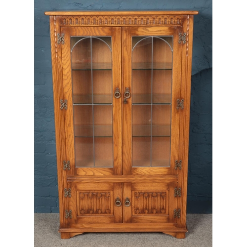 566 - A Priory style carved light oak lead glazed display cabinet. (153cm x 91cm)