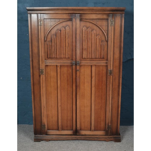 549 - An Old Charm carved oak three piece bedroom suite. Comprising of two wardrobes and dressing table.