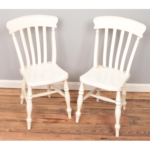 496 - A pair of white painted kitchen chairs.