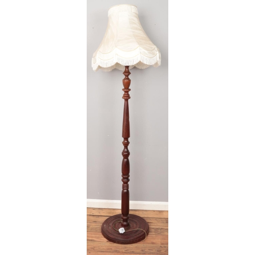 497 - A turned mahogany standard lamp with circular base.