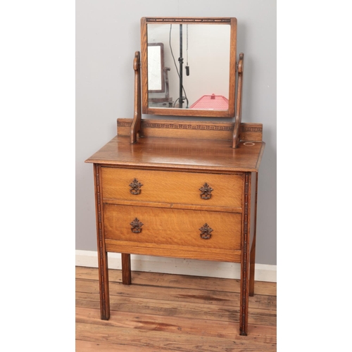 498 - A carved oak dressing table with two drawers.