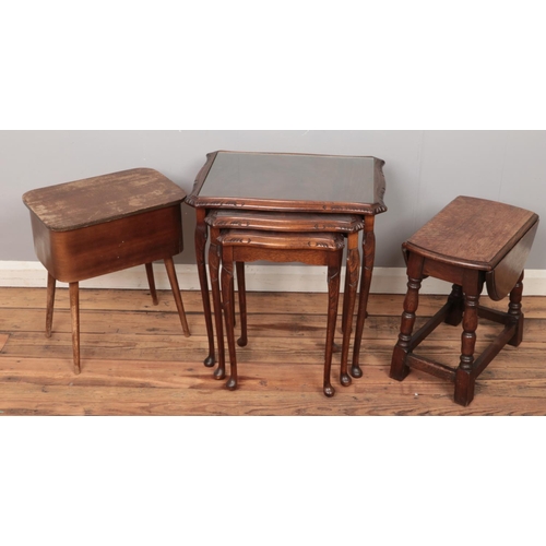 499 - A mahogany nest of three tables along with a sewing box and occasional drop leaf table.