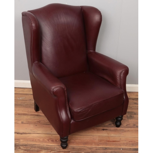 501 - A brown leather wingback armchair.