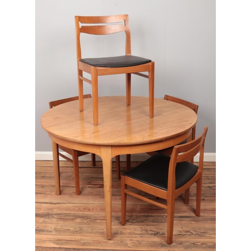 512 - A Nathan teak extending circular dining table along with a set of four chairs.