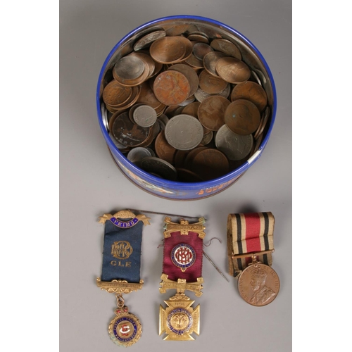 152 - A tin of coins and medals. Including half crowns, masonic medals, pennies, foreign coin examples, et... 