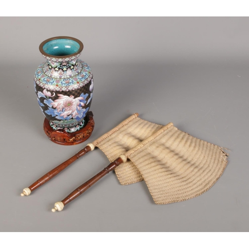 167 - A cloisonne floral vase with carved wood stand and pair of rattan and hardwood banners.