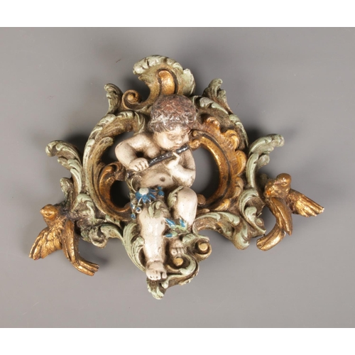 169 - A wall-hanging plague depicting a flute playing cherub. Approx. dimensions 32cm x 27cm.