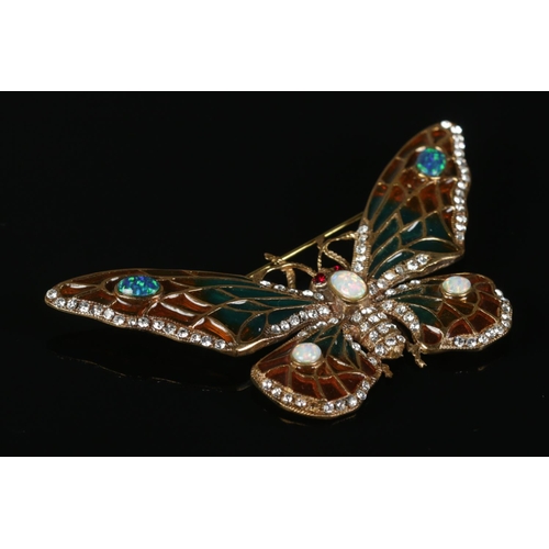 312 - A large yellow metal brooch formed as a butterfly, set with opal and paste stones. 8cm wide.