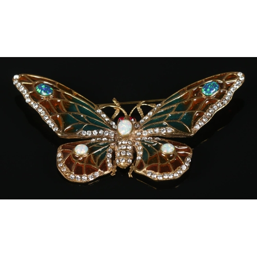 312 - A large yellow metal brooch formed as a butterfly, set with opal and paste stones. 8cm wide.