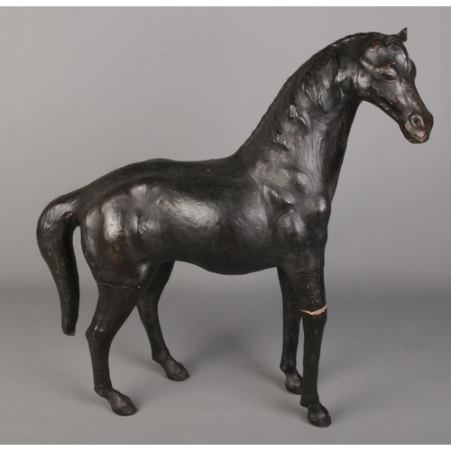 77 - A large leather mounted model of a horse. (51cm)