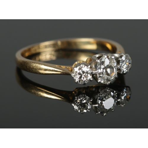 371 - An 18ct Gold and Platinum three stone diamond ring, with central oval cut stone being over ¼ct. Size... 