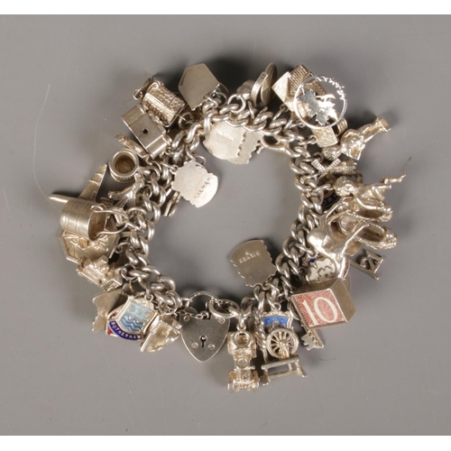 374 - A boxed silver charm bracelet with approx. 45 silver charms. Bracelet hallmarked Birmingham 1961. To... 