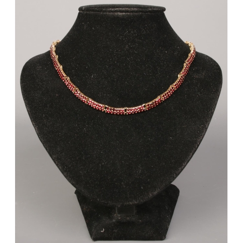 393 - A silver gilt garnet necklace, stamped 900 to the clasp.