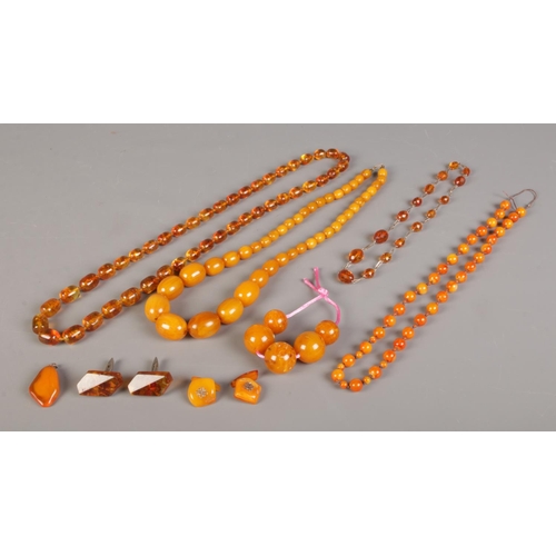 405 - A collection of amber and amber coloured beads. To include necklaces, cufflinks and pendant etc.