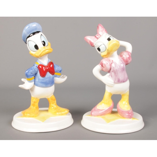 439 - Two Schmid Disney figures of Donald and Daisy duck, raised on circular star bases. 18cm high.