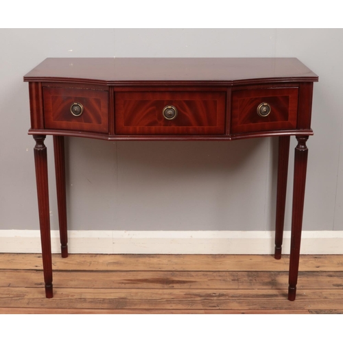 475 - A mahogany three drawer side table with reeded tapering supports.