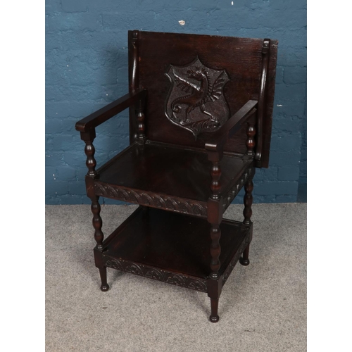 476 - An oak three tier folding top table/hall chair featuring carved dragon cartouche.