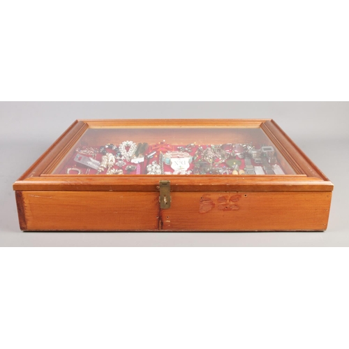 54 - A large tabletop bijouterie cabinet containing an assortment of costume jewellery. To include neckla... 