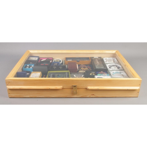 63 - A large tabletop bijouterie case, with contents of costume jewellery and collectables. To include cu... 