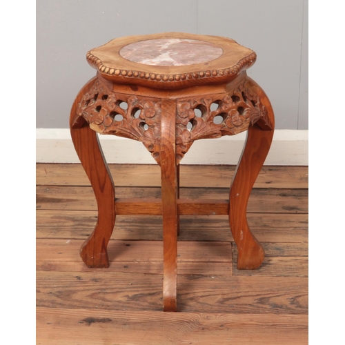 488 - An oriental hardwood plant stand with inset marble top and carved floral decoration. Approx. dimensi... 