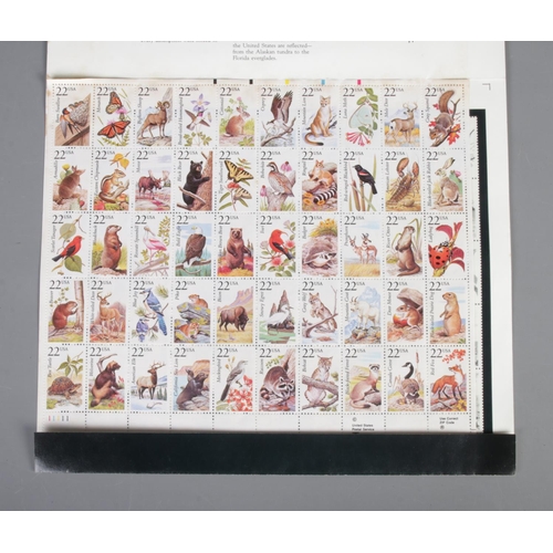 173 - A collection of stamps to include selection of first day covers, album of international examples and... 