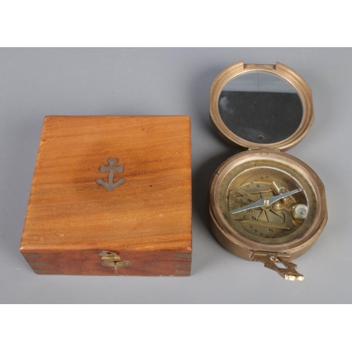 201 - A cased nautical brass compass, with 'Natural Sine' figures to the front and anchor inlaid in case.