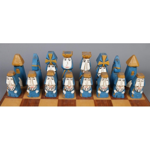 264 - Hand carved and painted wooden chess set and board, together with two wooden storage boxes. Board si... 