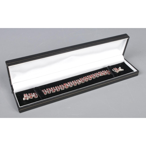 404 - A silver and garnet set bracelet, in box.