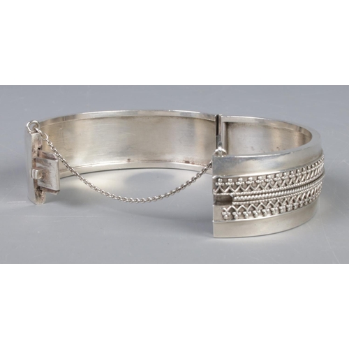 413 - A Victorian hinged bangle, with wirework decoration to half of the band. Tests as silver. Total weig... 