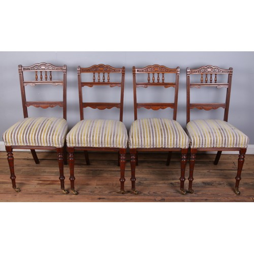 484 - Four upholstered dining chairs featuring carved decoration on turned front supports, two with castor... 