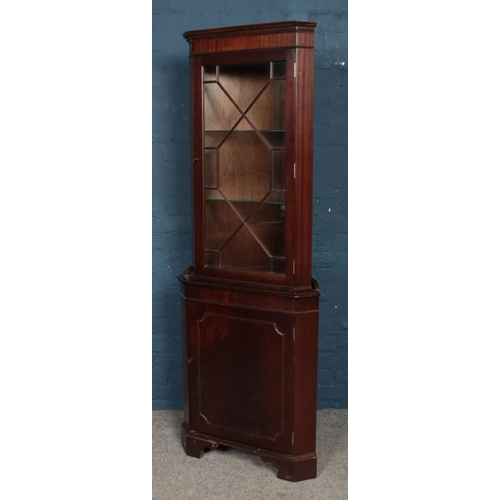 567 - A mahogany corner cabinet, with astragal glazed panel and hinged lower cupboard door. Height: 180cm,... 