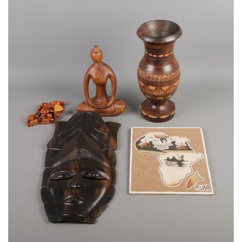 144 - A quantity of carved African items including mask, vase and figure of a seated woman. Also includes ... 