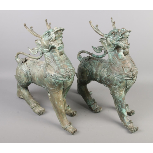 220 - A pair of bronze Tibetan style Qilin/Gilen sculptures. Height 39cm.